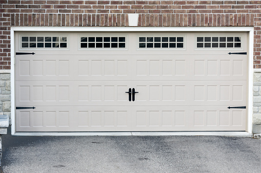 White, new garage doors, for two cars, in a new large cottage