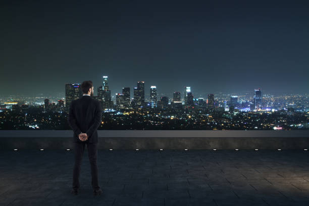 istock businessman on rooftop at night 1026003452