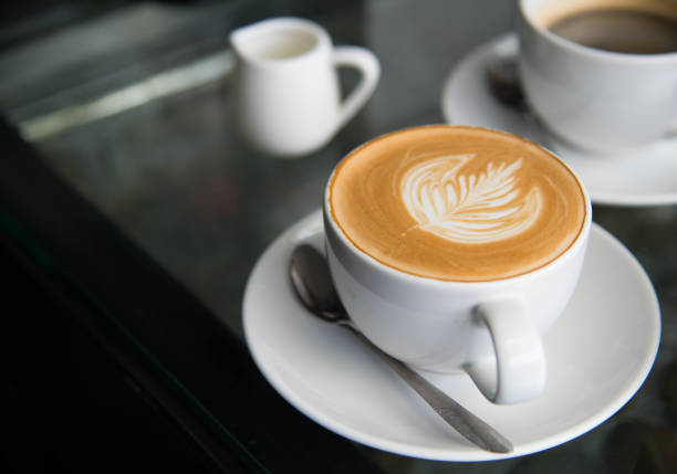 istock White cup of coffee latte art leave from fresh milk on the table. 1026013142