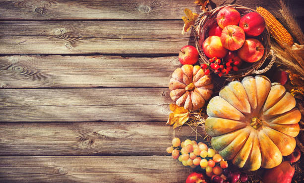 istock Thanksgiving background with pumpkins and falling leaves on rustic wooden table 1026013232