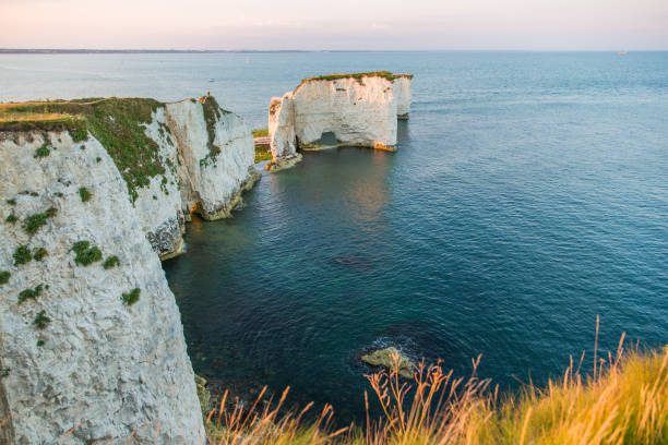 istock Couple Watching Sunset on Old Harry Rocks White Cliffs and Bournemouth 1026018484