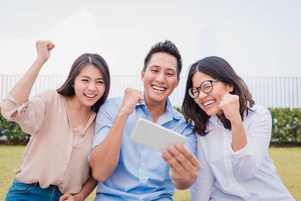 istock Asian friends celebrate while watching smartphone 1026026690