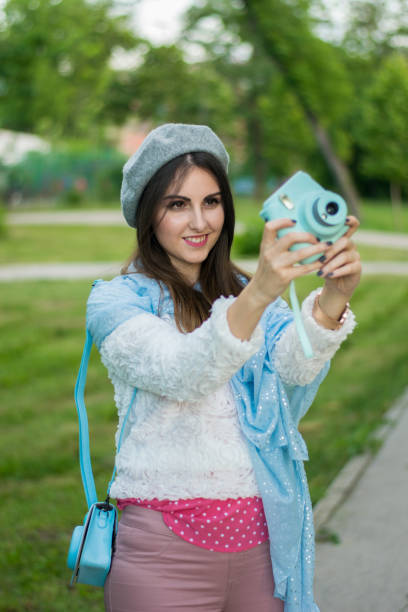 istock Woman with instant camera outside 1026039564