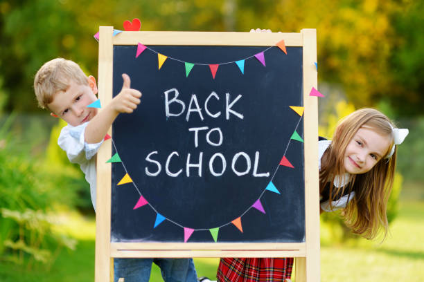Two adorable little schoolkids feeling exited about going back to school