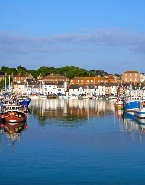 Reflection across water Weymouth Dorset Looking across the water to the boats near Weymouth Harbour in the summer on holiday. weymouth dorset stock pictures, royalty-free photos & images