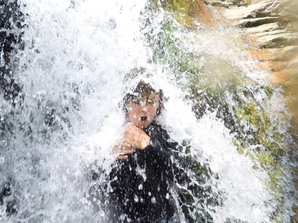 용감한 아이 사막에서 강력한 폭포 아래 서 - awe beauty in nature waterfall cool 뉴스 사진 이미지