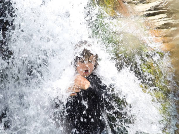 istock Brave child stands under a powerful waterfall in the desert 1026056678