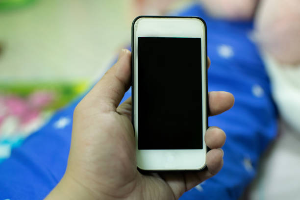 istock A white mobile phone in hand. And the background blurred. 1026061192