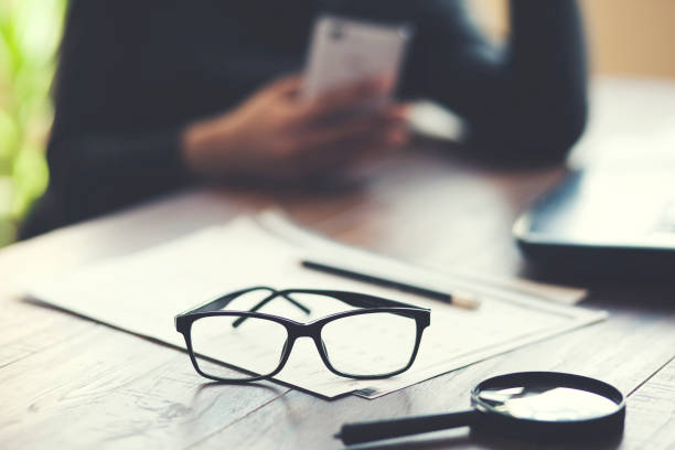 istock woman hand  phone and document on table 1026069700