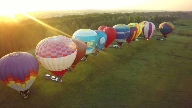 istock Balloons fly up in sky with passengers over green field 1026070142