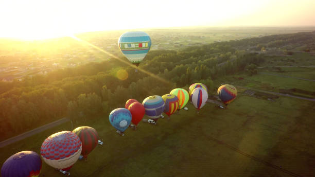 istock Balloons fly up in sky with passengers over green field 1026070430