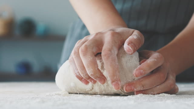 Female hands are kneading dough