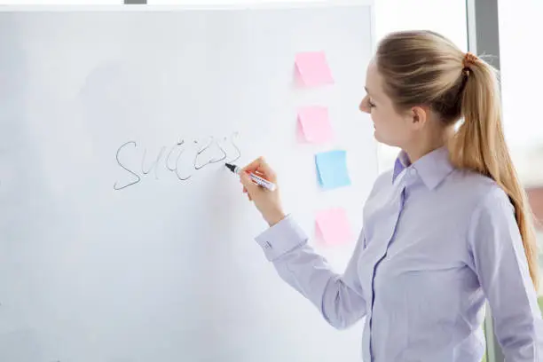 business woman writing success on white board in office,work place meeting room