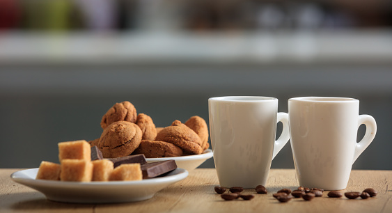 Cups of coffee and cookies on an office table