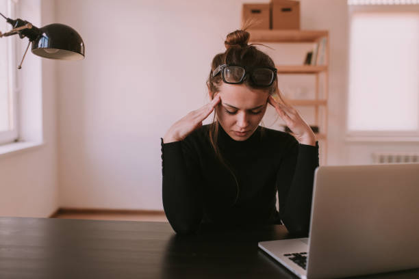 istock Woman with headache in office 1026127160
