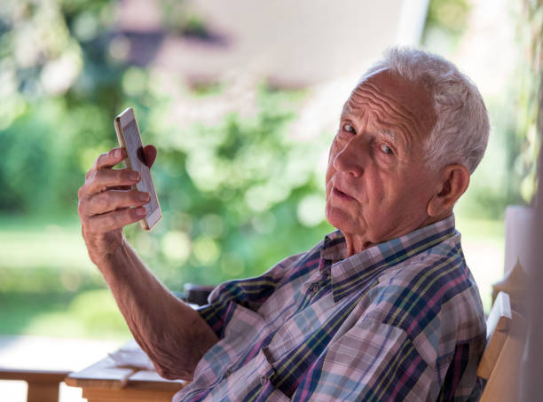 istock Old man talking on mobile phone in garden 1026131872