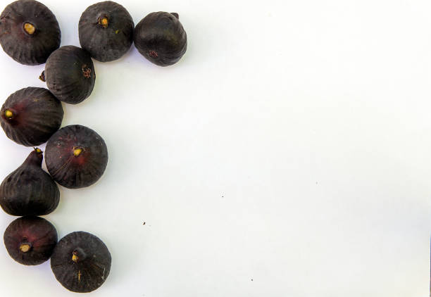 Fresh ripe sweet figs on white paper with copy space. stock photo