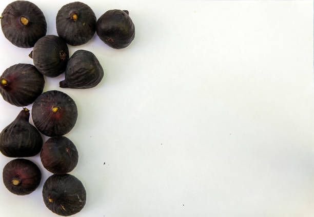 Fresh ripe sweet figs on white paper with copy space. stock photo