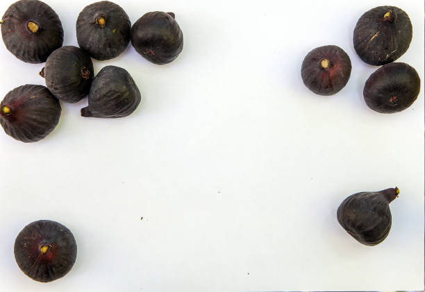 Fresh ripe sweet figs on white paper with copy space. stock photo