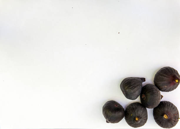 Fresh ripe sweet figs on white paper with copy space. stock photo