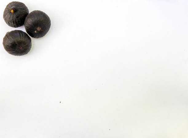 Fresh ripe sweet figs on white paper with copy space. stock photo