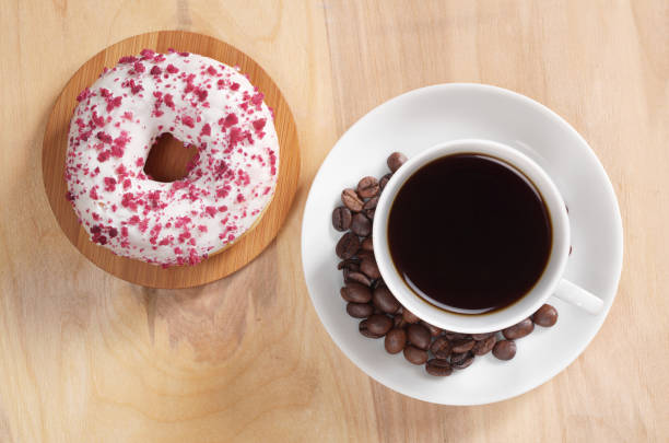 Coffee and sprinkled donut with white glaze