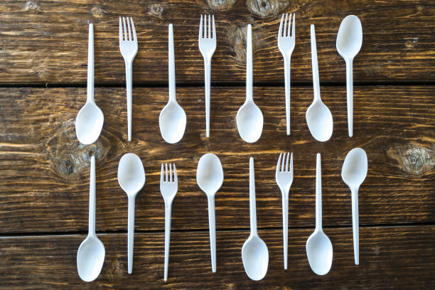 istock White plastic spoons and forks on a wooden background. 1026135698