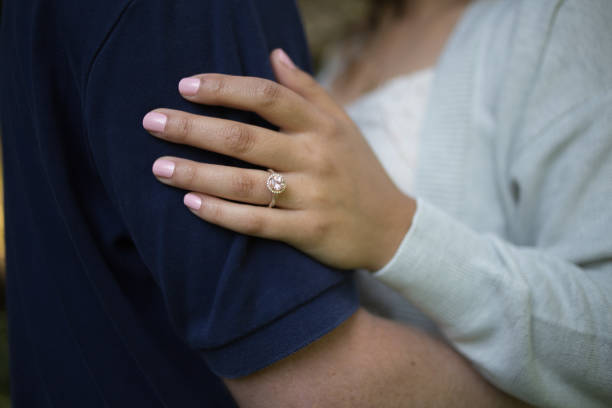 istock Romantic Newly Engaged Loving Couple Embracing Featuring Pink Diamond Engagement Ring on a Well Manicured hand with Pink Nail Polish 1026138562