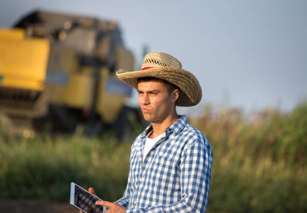 istock Farmer with tablet standing in front of combine harvester 1026155280