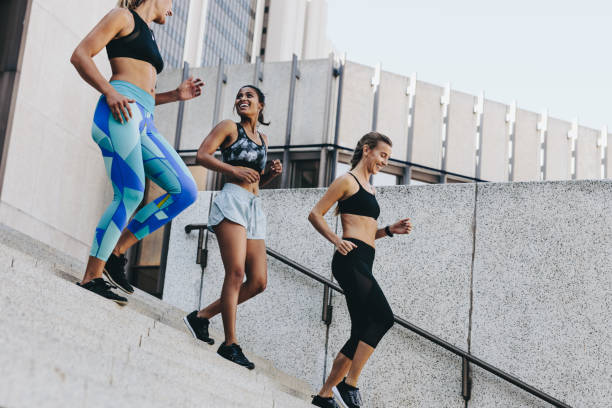 istock Smiling women in training clothes walking down the stairs 1026164326