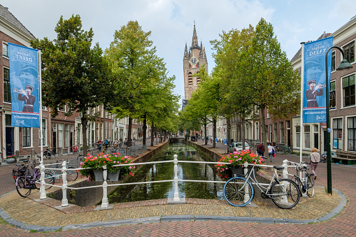 Delft, the Netherlands - Aug 21, 2018 : The oldest canal in the historical city of Delft, Netherlands, with a view of the leaning tower of the Oude Kerk.