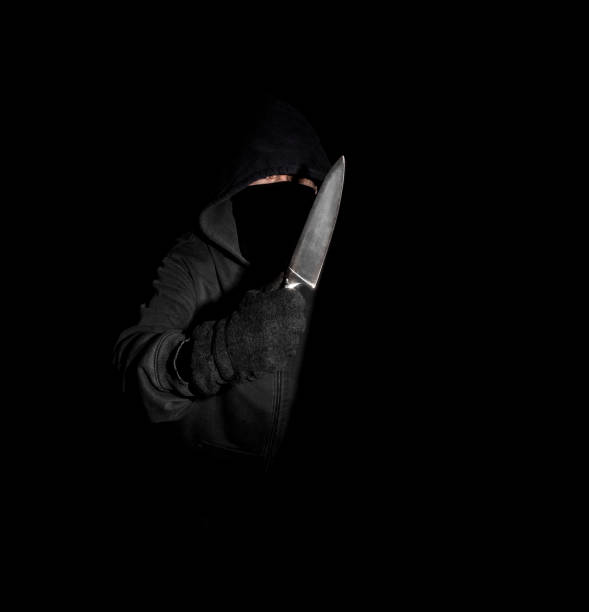 istock Hooded man with a knife - Black Background 1026164722