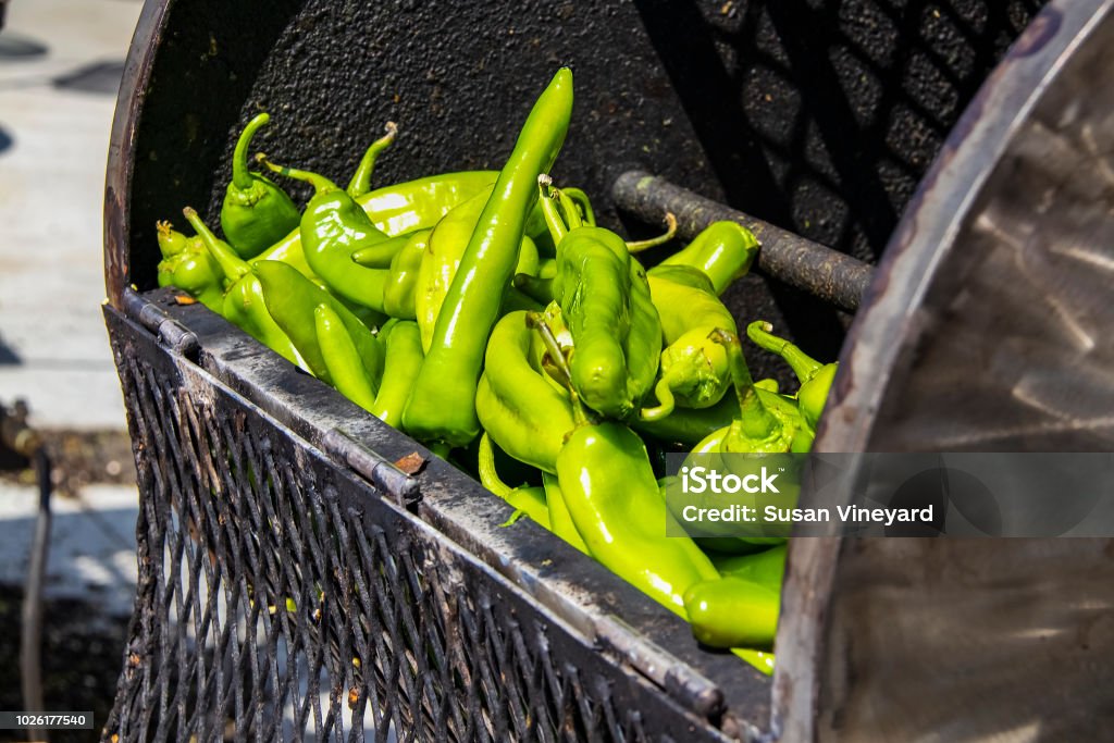 Fresh hatch chilis in an outdoor barrel roaster getting ready to be cooked Green Chili Pepper Stock Photo