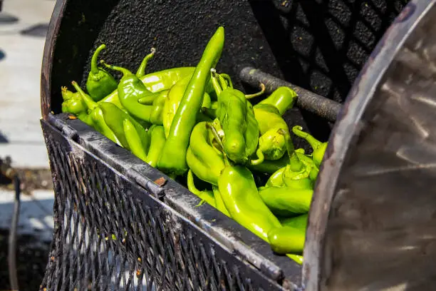Photo of Fresh hatch chilis in an outdoor barrel roaster getting ready to be cooked