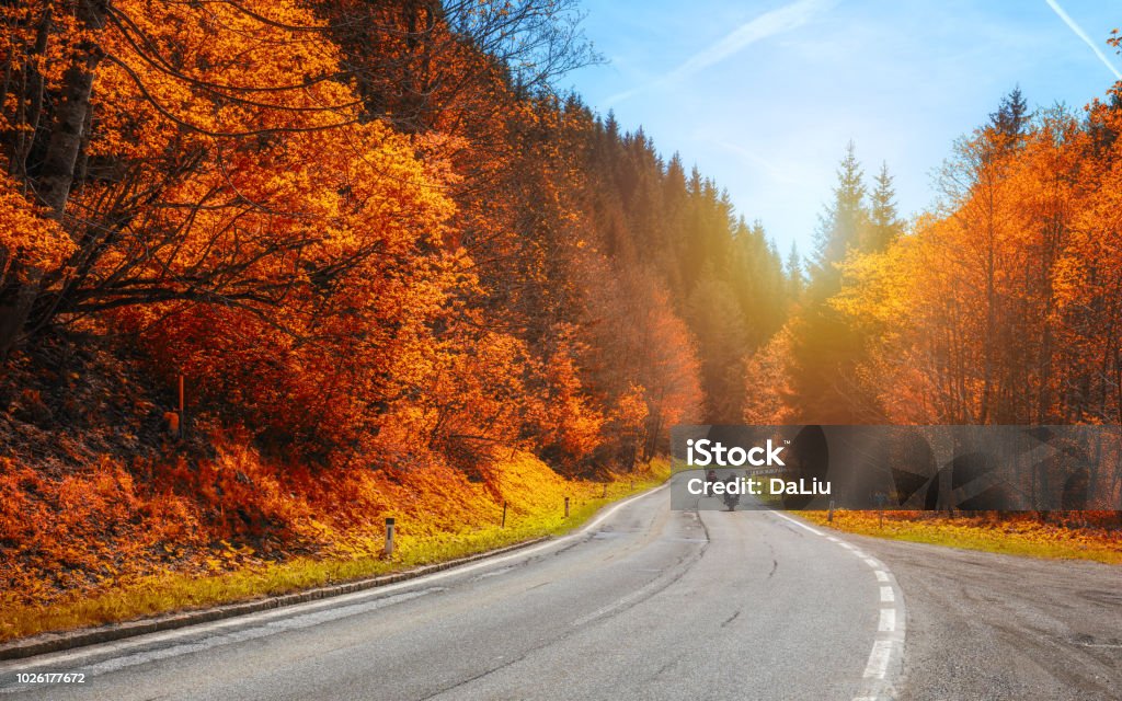 Bikers on mountainous highway, biker on the road in sunset light in autumn riding on curve road pass across Alpine mountains, extreme lifestyle, freedom concept. Austria, Alps Motorcycle Stock Photo