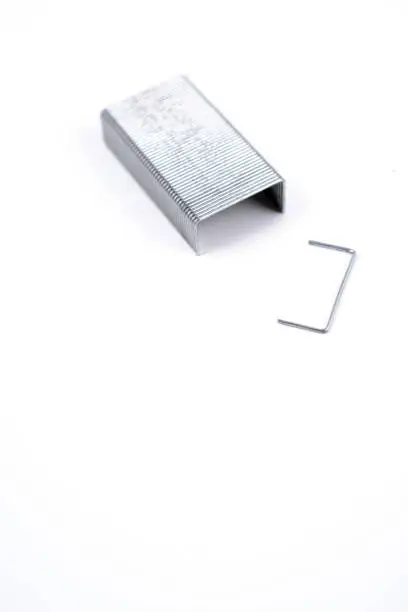 Closeup of set of metal staples lying on white background