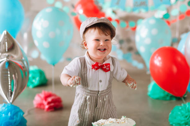 istock Baby boy touching his first birthday cake. Making messy cakesmash in decorated studio location 1026195532