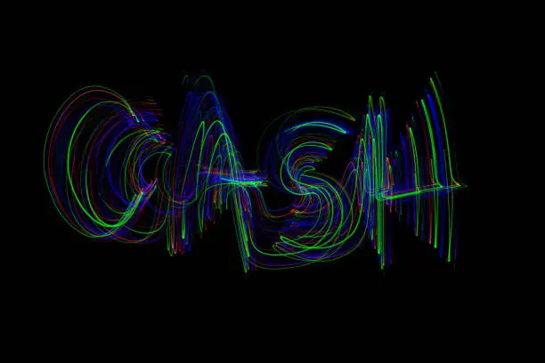 The word ‘CASH’ painted in the air in motion trails, captured on a long exposure. This text light painting on a black background consists of vibrant neon colours which are abstract, modern, stylish and unique.