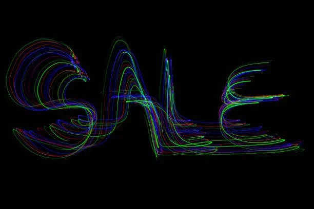 The word ‘SALE’ painted in the air in motion trails, captured on a long exposure. This text light painting on a black background consists of vibrant neon bright colours which are abstract, modern, stylish and unique. v2