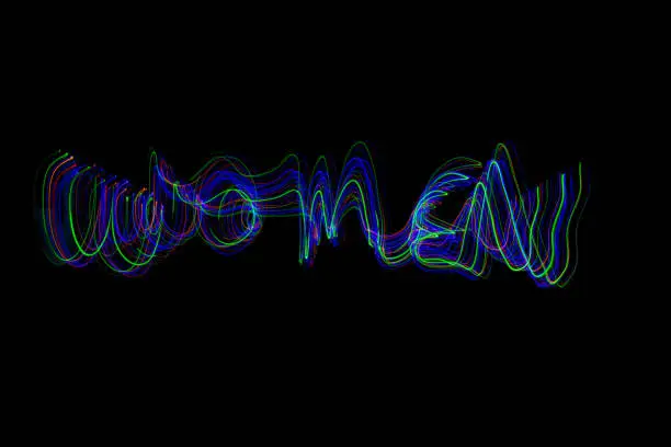 The word ‘WOMEN’ painted in the air in motion trails, captured on a long exposure. This text light painting on a black background consists of vibrant neon colours which are abstract, modern, stylish and unique. Look for MEN v2, for the matching pair.