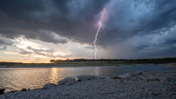 istock Large Lighting From Dark Clouds During Sunset At Large Lake 1026199294
