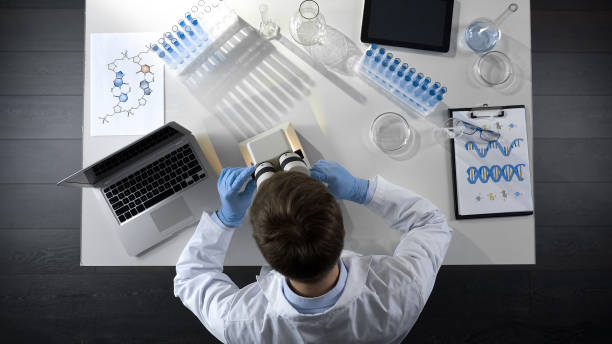 istock Top view of laboratory worker examining prepared sample under microscope 1026202622