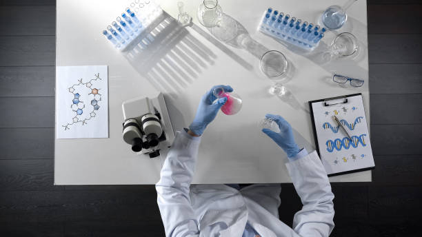 istock Chemistry student mixing chemical agents in flask, conducting color experiments 1026202712