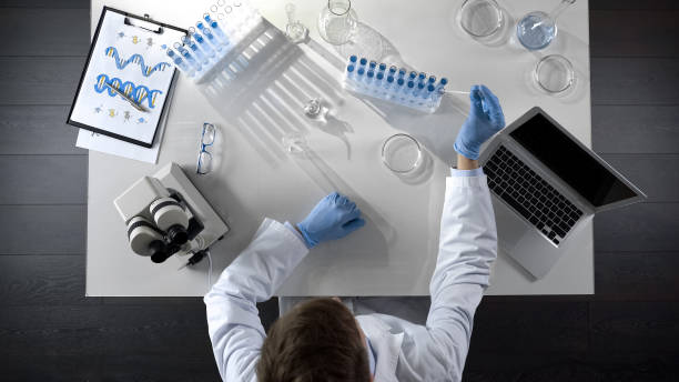 istock Student taking reagents and watching chemical experiement in lap, top view 1026202774