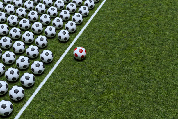Red Colored Soccer Ball Standing Out From The Crowd stock photo