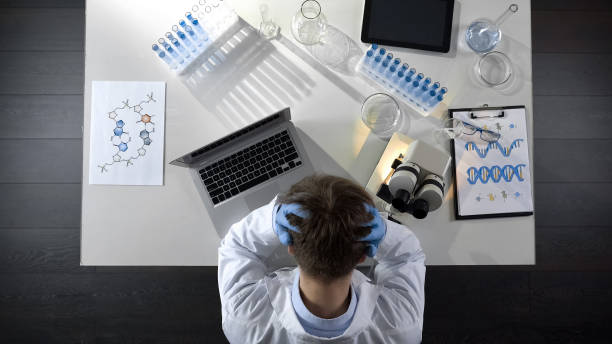 istock Disappointed laboratory worker sitting upset by experiment failure, top view 1026204996