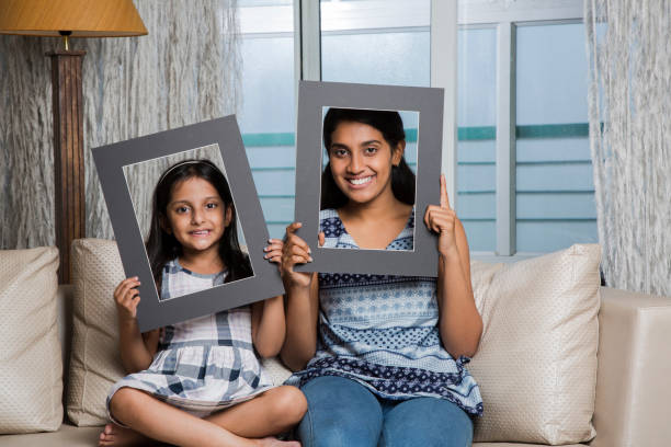 istock family looking through white frame - Stock Images 1026226998