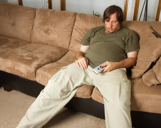 Guy passed out on the couch stock photo