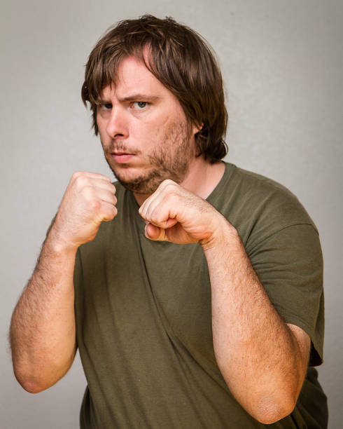 Fist up and ready to brawl A guy ready to fight with his fist up in the air punching one person shaking fist fist stock pictures, royalty-free photos & images