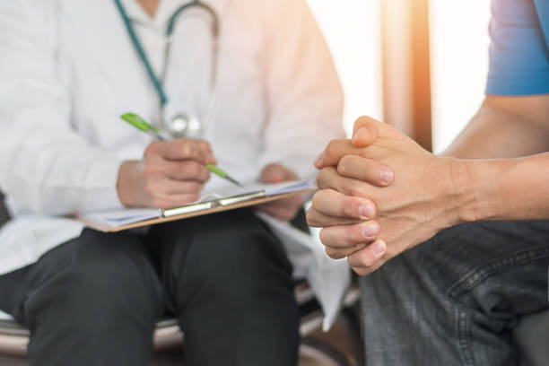 paciente masculino de tener consulta con el médico o psiquiatra que trabaja en el examen diagnóstico en salud enfermedad o enfermedad mental de los hombres en el centro médico de servicio de salud mental de clínica u hospital - acontecimiento anual fotografías e imágenes de stock